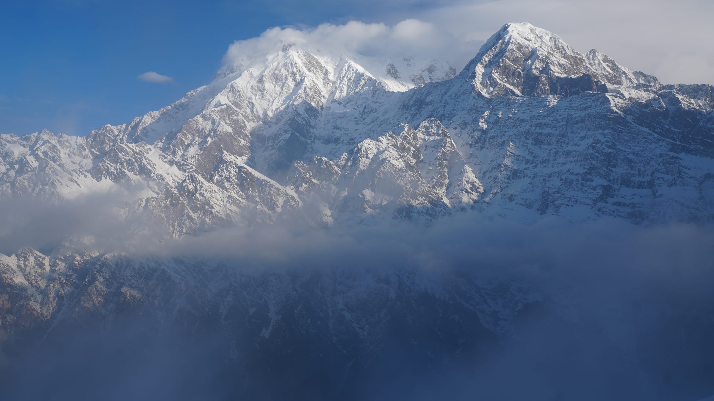 Snow-covered mountain peaks rising above a sea of clouds